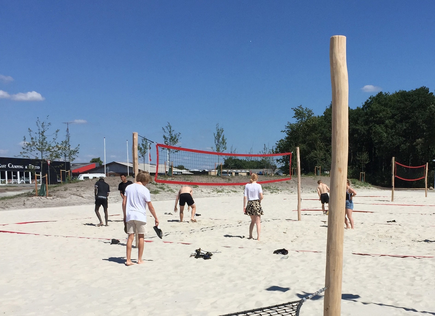 Igangværende beachvolley kamp ved siden af Hjertet i et stort sand-areal